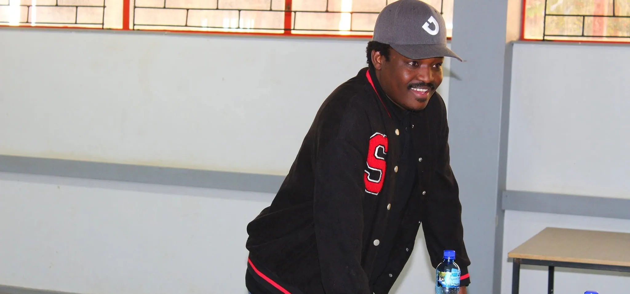 Thabiso Naleli in a school hall classroom with a small drone on the desk
