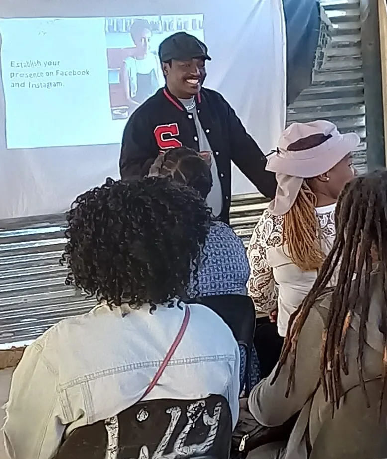 Thabiso Naleli presenting to a seated community group during a practical session